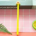 Cute yellow gel pen with rainbow cloud topper featured on a pink grid background pattern. - 0.5mm Pen Point / Yellow