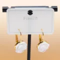 Close-up of elegant white rose flower earrings with gold-tone hooks on display card. - C-598 Gold