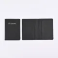 Black PU leather passport cover detail showing interior card slots and smooth oil edges. - Black