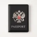Black PU leather passport cover with metal double eagle emblem and card slots for travel. - Black