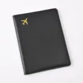 Black PU leather passport holder with gold airplane accent, minimalist travel wallet cover. - Passport Cover / Black