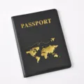 Detail view of black PU leather passport cover with gold stamped map and passport text. - 14.2*10.8cm / Black