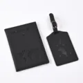 Close-up detail of the black PU leather passport holder and matching travel luggage tag set. - Black