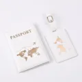 Detail shot of a white PU leather passport cover and luggage tag set with gold world map. - White
