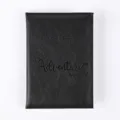 Close-up view of black PU leather passport holder with debossed travel quote detail. - Folded Size 14*10cm / Black