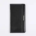 Detail view of black glitter PU leather passport cover with elastic band and metal decoration. - Black