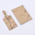 Detailed view of the beige marble pattern PU leather passport cover and matching luggage tag. - Bronze