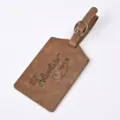 Brown PU leather luggage tag detail showing embossed adventure quote and airplane flight graphic. - Khaki