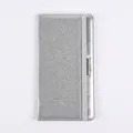 Detail view of silver glitter PU leather passport cover with elastic strap and metal accent. - Gray