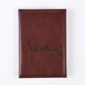 Detail view of dark brown PU leather passport cover with exquisite embossed travel quote texture. - Folded Size 14*10cm / Burgundy