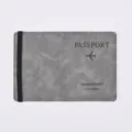 Close-up detail of grey PU leather passport holder cover with black elastic band and print. - Space Gray