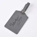 Grey PU leather luggage tag close-up, engraved adventure quote, durable travel accessory id. - Gray