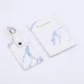 Detailed view of white marble pattern PU leather passport holder and matching luggage tag set. - Blue 2