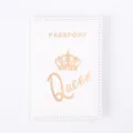 Detailed close-up view of the white PU leather passport cover with crown and gold print. - White