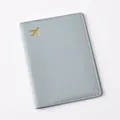 Detailed view of grey PU leather passport holder featuring gold foil airplane pattern. - Passport Cover / Light Blue
