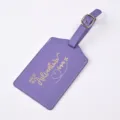 Purple PU leather luggage tag detail featuring gold foil quote and elegant gold buckle. - Purple