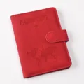 Detailed close-up of red PU leather passport holder with magnetic closure and debossed world map. - Passport Cover / Red