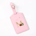 Pink leather luggage tag with gold letter M and airplane detail, perfect for travel bags. - Letter M / Pink
