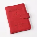 Detailed view of red PU leather passport holder with magnetic buckle and airplane embossed logo. - Passport Cover / Red