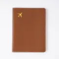 Brown passport cover featuring white stitching and gold airplane design for travel use. - Passport Book / Brown