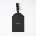 Black PU leather luggage tag with gold airplane motif and adjustable metal buckle. - Luggage Tag / Black