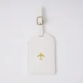 White PVC luggage tag with gold airplane icon, durable travel bag label with buckle strap. - Luggage Tag / White