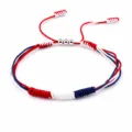 Detailed view of the red, white, and blue braided handmade friendship bracelet. - United states australia