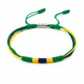 Close-up of handmade braided friendship bracelet in flag colors with three copper beads - Brazil