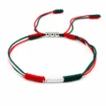 Macro detailed view of a hand-woven flag color bracelet with three silver metallic beads - Mexico