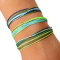 Primer plano de tres juegos de pulseras ajustables trenzadas con cordón de cera de colores en la muñeca - Estilo Azul Blanco Verde (1) / Set de tres piezas