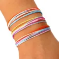 Primer plano de un juego de tres pulseras de playa de cordón de cera trenzado de colores. - Estilo Naranja Blanco Azul Amarillo (4) / Set de tres piezas