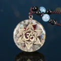 Primo piano del ciondolo in cristallo Orgone con loto dorato e simbolo Om inciso - Stile Loto Tondo (3087)