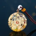 Vista macro del ciondolo Orgone con cubo di Metatron, foglia d'oro e cristalli vari. - Cubo di Metatron (Orgone)