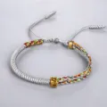 Bracelet tibétain tissé à la main avec nœuds colorés et une perle de mantra dorée. - Gris