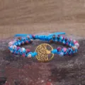 Primo piano di bracciale fatto a mano in pietra imperiale con ciondolo albero della vita oro. - Bracciale Doppio Strato Intrecciato a Mano