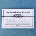 Handgefertigtes Amethyst-Kristall-Energie-Perlenarmband auf einer weißen Intentionskarte - Lila