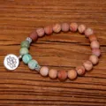 Detalle de pulsera artesanal de cuentas de piedra de madera con dije de loto para yoga - Pulsera