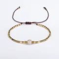 Handmade Bohemian braided friendship bracelet with gold beads and a round semi-precious stone - Brown