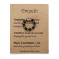 Ring aus Hämatit- und Amethystperlen auf einer dekorativen Kraftpapierkarte präsentiert - Hämatit Amethyst Schwarzer Turmalin Stil (3618)