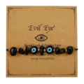 Handgefertigtes Evil Eye Armband mit schwarzen Steinen und blauen Glasperlen auf Karte - Schwarz