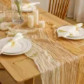 Vista dettagliata del runner da tavola plissettato boho in garza sfumata per festa di nozze. - 90*300cm / Bianco sporco, champagne e albicocca (tricolore)