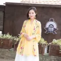 Detailed outdoor scene showing ethnic embroidered cotton linen shawl scarf in yellow. - 90x170cm / Turmeric