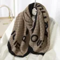 Detailed close-up view of pleated winter scarf featuring monogram pattern and bold letter print. - Style 11