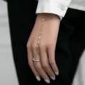 Silver 925 sterling silver finger bracelet featuring delicate CZ stones worn on a hand - Ring Diameter 16mm / White Gold