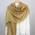 Elegante effen mosterdgouden modal katoen linnen sjaal voor dames gedrapeerd op een hanger - Gembergeel / 180cm