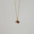 Gros plan d'un collier doré avec un pendentif carré en zircone violette et un petit diamant - Février
