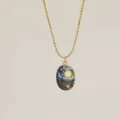 Detail shot of a gold ball chain necklace featuring a Van Gogh Starry Night pendant. - The Starry Night