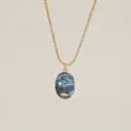 Macro view of luminous Starry Night lighthouse pendant on gold ball chain - Lighthouse