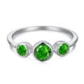 Detalle de anillo de plata S925 con tres piedras preciosas de esmeralda verde - Estilo de Eternidad Tres Piedras