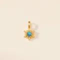 Vue rapprochée du pendentif étoile à huit branches avec gemme bleue en acier doré - Décembre (Topaze Bleue)